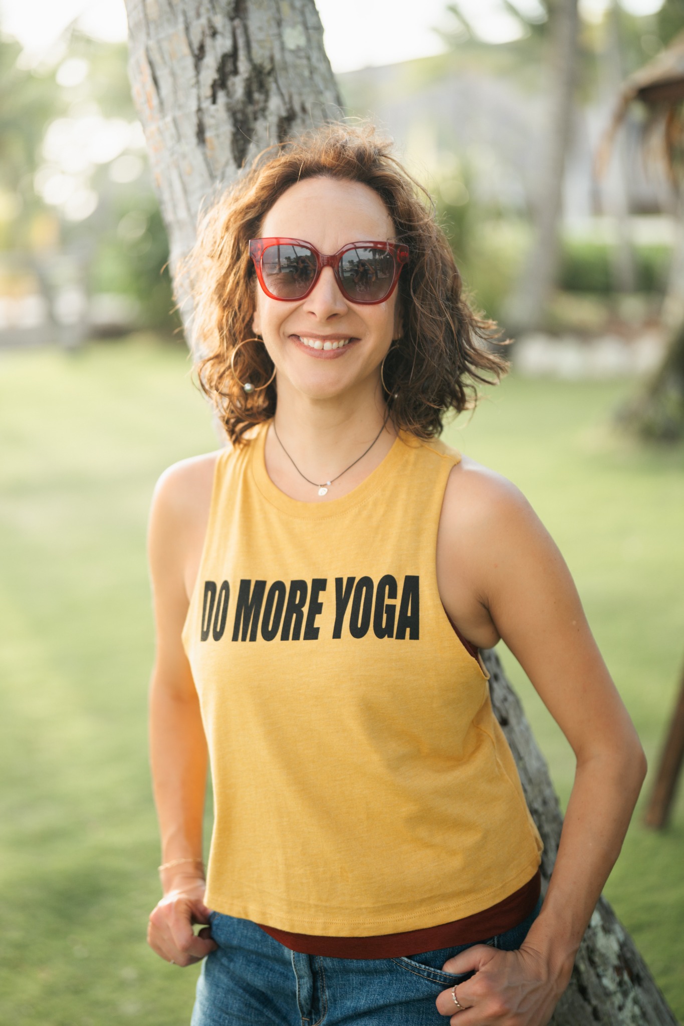 Anna smiling outdoors in a Do More Yoga shirt